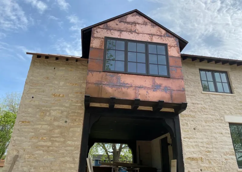 Copper metal panel facade on a stone building for Roof Repair in Flower Mound
